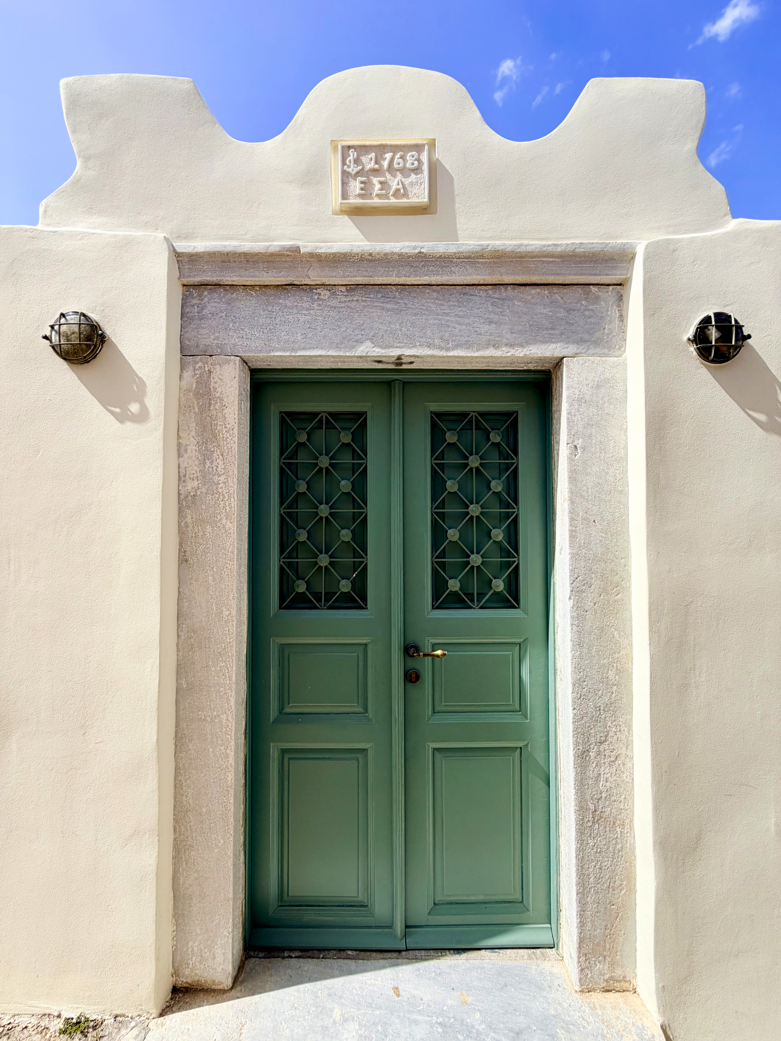 A green door in Oia, typically representing a home connected to farming or agriculture A green door in Oia, typically representing a home connected to farming or agriculture